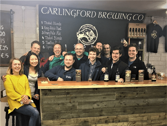 Tour group posing for a photo behind the bar at Carlingford Brewing Co.